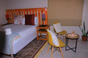 a bedroom with a bed and two chairs and a table at Gwanxhae Boutique Accommodation in Maun