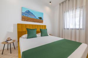 a bedroom with a large bed with green pillows at Case Vacanza Loria in Castelluzzo