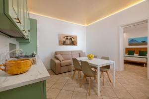 a kitchen and living room with a white table and chairs at Case Vacanza Loria in Castelluzzo