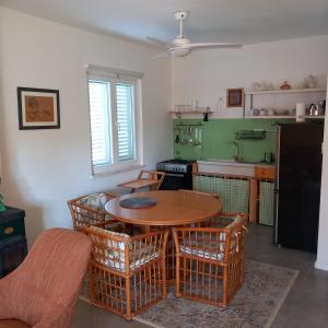 a kitchen with a wooden table and chairs in a kitchen at Petra's House in Komaji