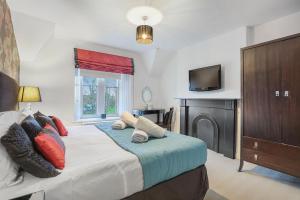 une chambre avec un lit avec une télévision dessus dans l'établissement Grove Cottage - North East Escapes, à Bamburgh