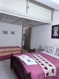 a bedroom with a bed with a purple blanket at Appartamento ''Il sole'' in Realmonte