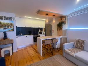 a kitchen and living room with a couch and a table at Museuflat in Póvoa de Varzim