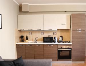 a kitchen with white cabinets and a stove top oven at All'Ombra Della Reggia in Caserta