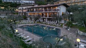 a hotel with a swimming pool in front of a building at Hotel Coste in Limone sul Garda