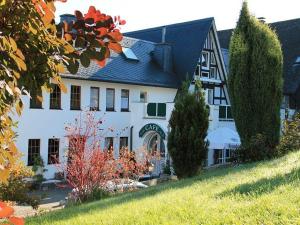 a large white house with a black roof at Hotel Bischof in Schmallenberg