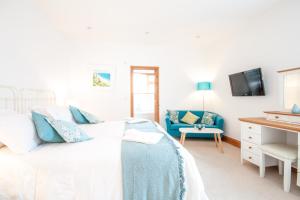 a bedroom with a bed and a blue chair at Padstow Bed & Breakfast in Padstow