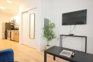 a living room with a table and a tv on a wall at The Platinum Downtown Stamford Studio Getaway in Stamford