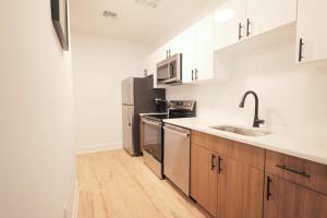 a kitchen with stainless steel appliances and wooden cabinets at The Platinum Downtown Stamford Studio Getaway in Stamford