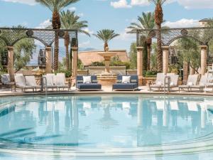 a swimming pool with chairs and a fountain at The Palazzo at The Venetian® in Las Vegas