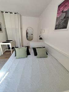 a room with a bed with two pillows and a piano at Studio Brest quartier St Michel in Brest