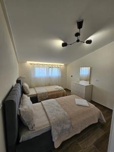 シュコダルにあるLa Casa di Fatmirのベッド2台とソファのある寝室