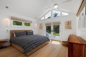 a bedroom with a bed and a large window at Coconut Hut in Kilauea