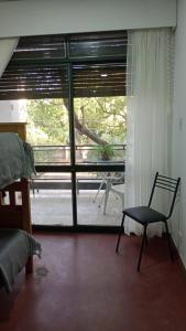 a room with a chair in front of a window at Urbano B&B 2A in San Juan +6 photos
