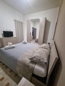 a bedroom with a large bed and a mirror at Holiday Home B&M Apt2 -Apt3 in Pozzallo