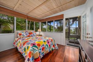 een slaapkamer met een bed in een kamer met ramen bij Hualalai in Kailua-Kona