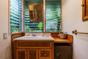 een badkamer met een wastafel en een raam bij Hualalai in Kailua-Kona +45 foto's