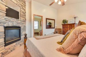 a bedroom with a fireplace and a tv on a stone wall at Eden Townhome with Mtn View and Shuttle to Powder Mtn! in Eden
