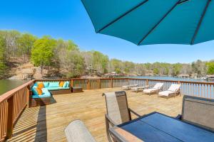 a deck with a table and chairs on a balcony at Smith Mountain Lake House with 2-Story Boat Dock! in Moneta