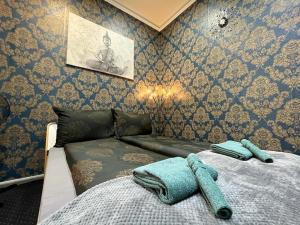 a bedroom with a bed with two towels on it at JohnGold Buddha Room in Debrecen +1 photo