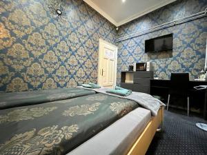 a bedroom with blue walls and a bed with a desk at JohnGold Buddha Room in Debrecen
