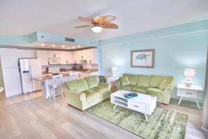 a living room with a couch and a kitchen at Lake Town Charming Condo Steps from the Beach in Panama City Beach
