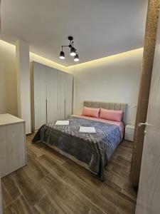 a bedroom with a large bed with pink pillows at La Casa di Fatmir in Shkodër