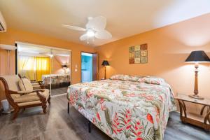 a bedroom with a bed and a chair and a mirror at Pu'u Nui in Waikoloa Village