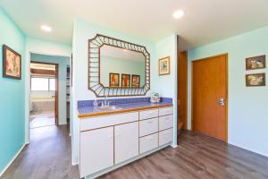 a bathroom with a sink and a mirror at Pu'u Nui in Waikoloa Village +71 photos