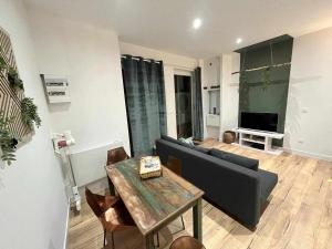 a living room with a couch and a table at Haut bercail - Duplex privatif in Steenvoorde