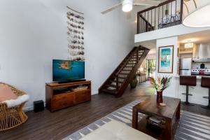 a living room with a television and a staircase at Turtle Bay Kuilima Collection 6 West in Kahuku