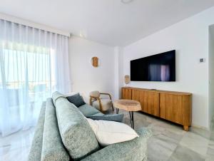 a living room with a couch and a tv at Beautiful first line Penthouse with Sea View Mi Capricho in Mijas Costa