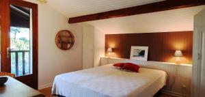 a bedroom with a white bed and a window at Résidence 03272-lacanau Ocean - Villa spacieuse , 3 chambres, 6 personnes, piscine privée à Lacanau océan MAE-0991 in Lacanau