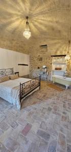 a bedroom with a large bed and a stone wall at Villa Adriatica - Character Home, Costa dei Trabocchi in Villalfonsina