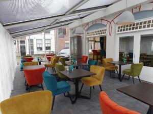 a restaurant with tables and colorful chairs at Villahotel Vlissingen in Vlissingen