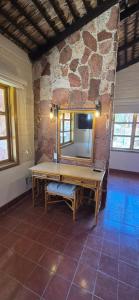 a room with a mirror and a bench in front of a stone wall at Sandy Shores Cabaña 8A in La Paz