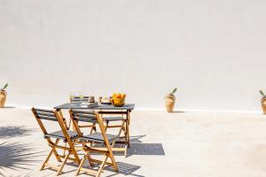 a table with two chairs and a bowl of oranges at Case Vacanza Loria in Castelluzzo