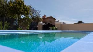 a swimming pool in front of a house at Domo Andi in La Maddalena