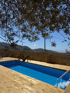 una piscina con una valla de madera y un árbol en Villa Sirentum Seaview Pool & Spa, en Sorrento