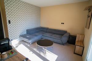 a living room with a blue couch and a table at Hôtel de la Mer in Hyères