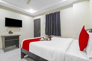 a hotel room with a bed and a television at Super Hotel O Honey Heights Near Botanical Garden in Kondapur