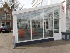 a store front with glass windows and chairs at Villahotel Vlissingen in Vlissingen