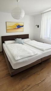 een groot wit bed in een slaapkamer met een raam bij Apartments Jolie in Vodice