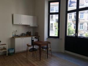 a kitchen with a table and chairs in a room at Charming studio in the heart of Saint-Gilles in Brussels