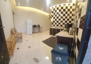 a kitchen with a counter and a refrigerator at منزل عوالي الصفا in Buraydah