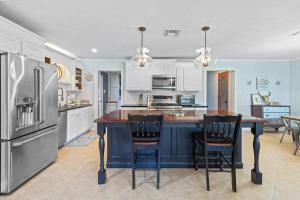 a kitchen with a large island with two bar stools at Cozy Sulphur Getaway, Pool and Basketball Court in Sulphur