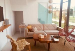 a living room with a couch and a table at Casa Milagres Morada do Toque l até 6 adultos in São Miguel dos Milagres