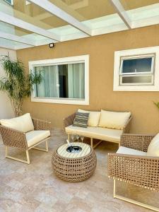 a patio with wicker furniture and a table and chairs at Casa na Serra com Área de Lazer in Nova Friburgo