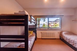 a room with two bunk beds and a window at Casa inmejorable ubicacion in San Carlos de Bariloche