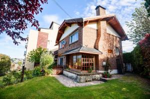 a brick house with a fence and a yard at Casa inmejorable ubicacion in San Carlos de Bariloche
